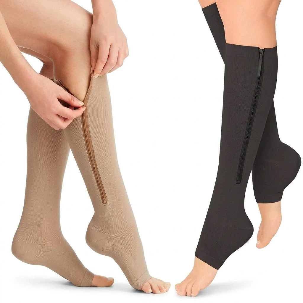 A person wearing beige and black open-toe compression socks with side zippers on their lower legs.