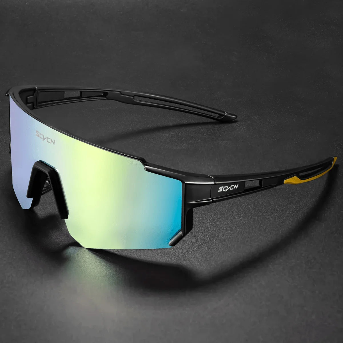 A pair of sleek, black-framed cycling sunglasses with a reflective, iridescent blue and yellow lens on a dark background.