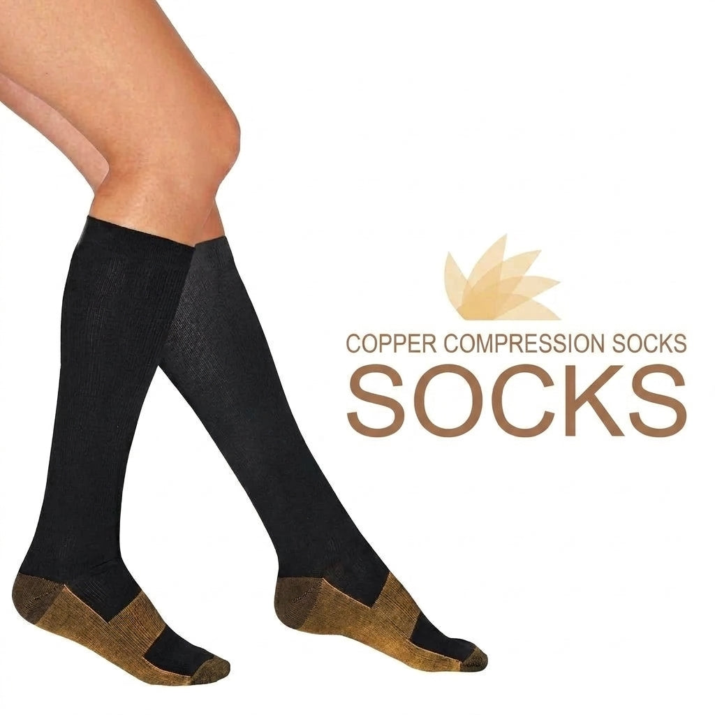 A pair of black copper compression socks with metallic-coloured heels and toes worn on a person's legs against a white background.
