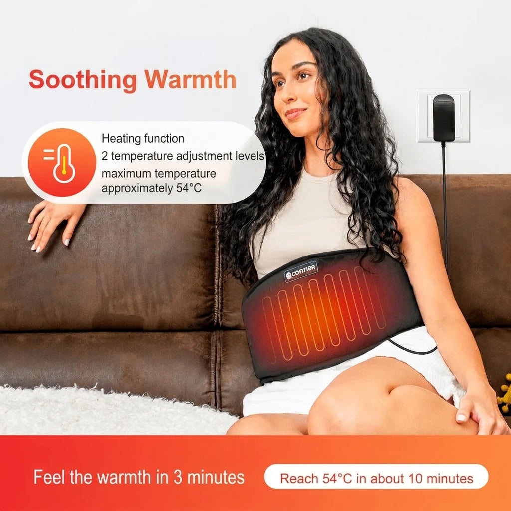 A woman sitting on a brown sofa wearing a Coafier heating belt around her waist, plugged into a wall outlet.