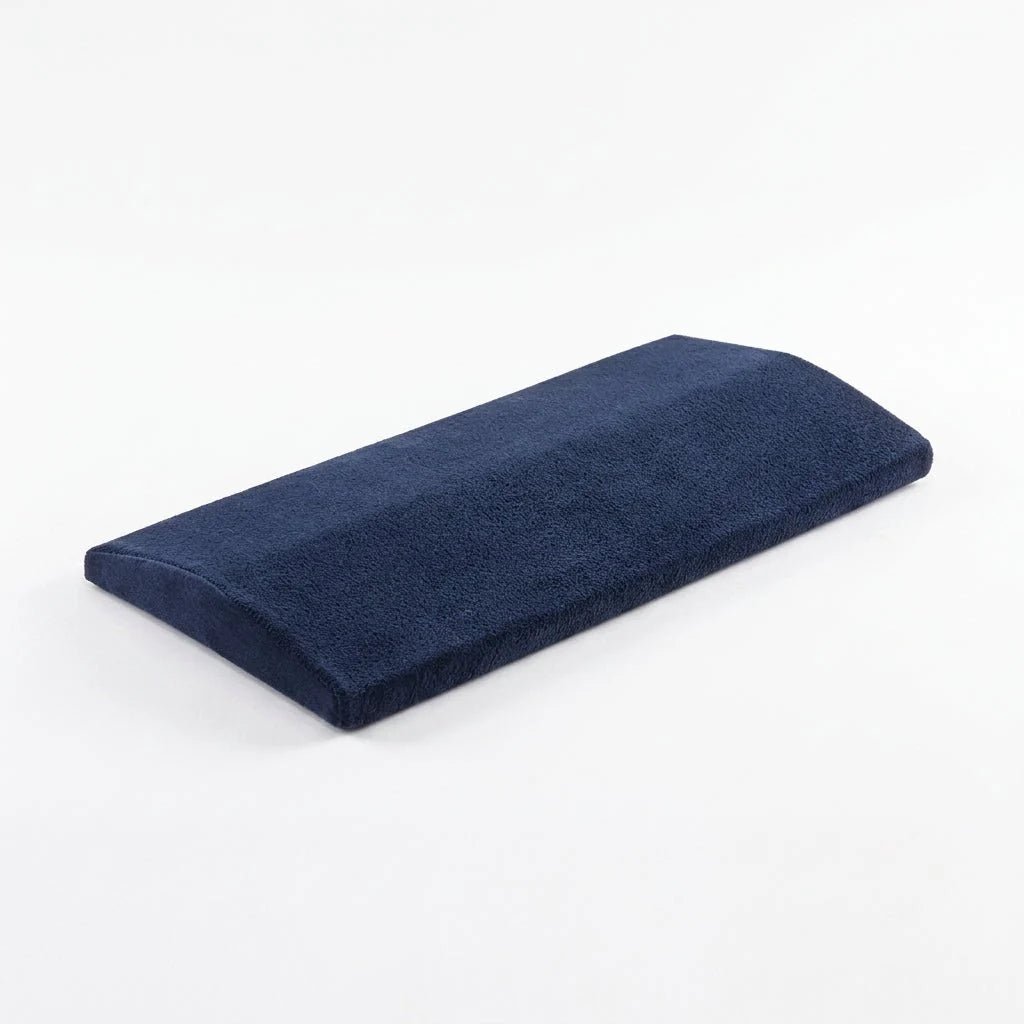 A navy blue, wedge-shaped lumbar support pillow with a soft, textured fabric cover, isolated against a white background.
