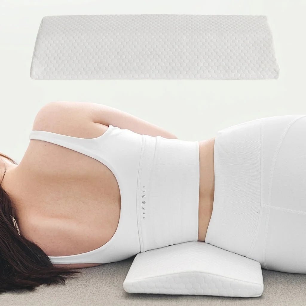 A person lying on their side using a white ergonomic lumbar support pillow under their lower back.