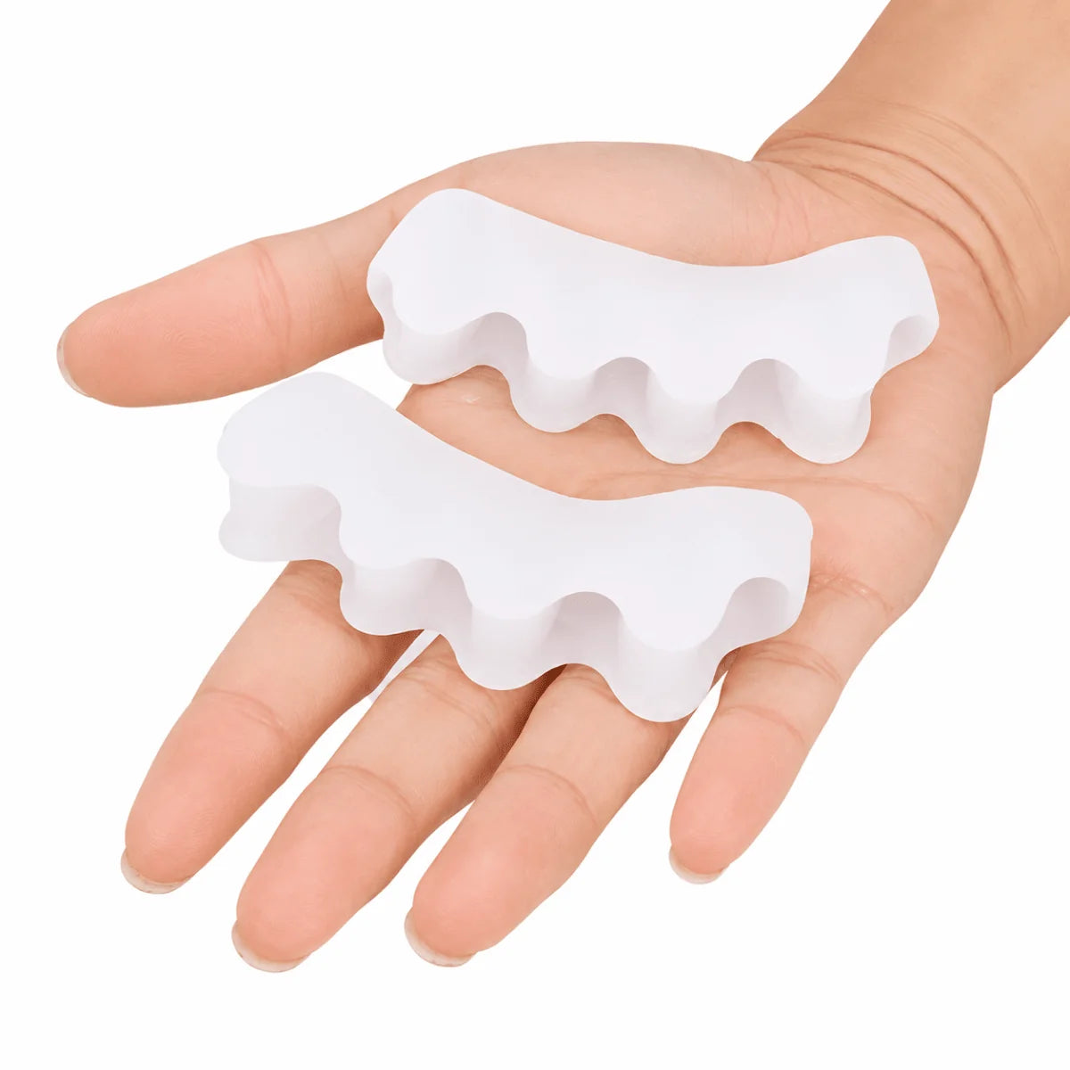 A person holding two white, flexible silicone gel toe separators in their palm to help with bunion and hammer toe relief.
