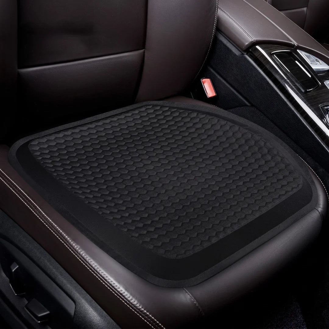 A black honeycomb-patterned cooling gel cushion placed on a brown leather car seat.