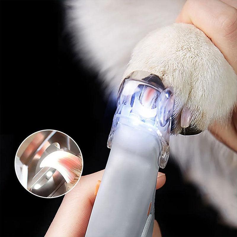 A person using illuminated stainless steel nail clippers to trim a dog's claw, showing the quick clearly through the light.