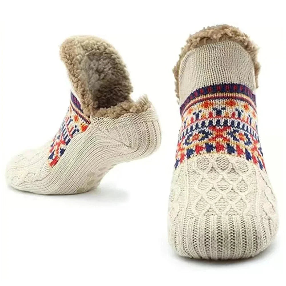 A pair of cream-coloured, fleece-lined winter grip socks with a patterned knit design and anti-slip soles.