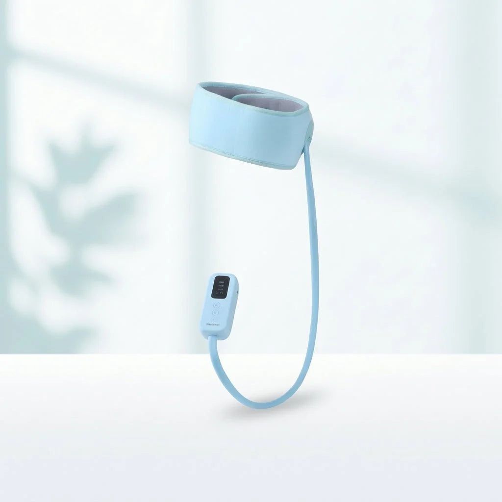 A light blue, adjustable head massager with a digital control unit attached by a cable, set against a soft, bright background.