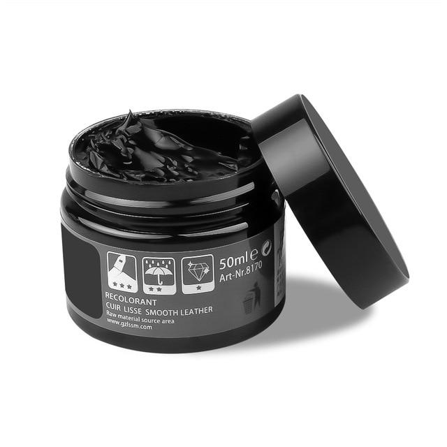 An open jar of black leather repair gel with a black lid, featuring product details and icons on the label.