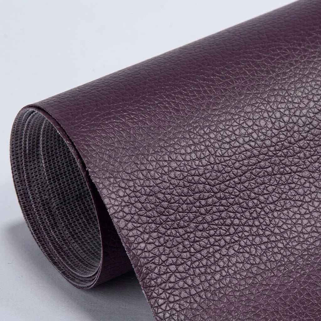 A roll of deep purple, textured self-adhesive leather repair patch material on a light grey background.