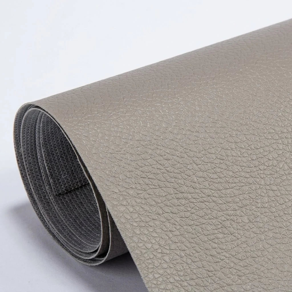 A roll of beige, textured self-adhesive leather repair patch material on a plain white background.