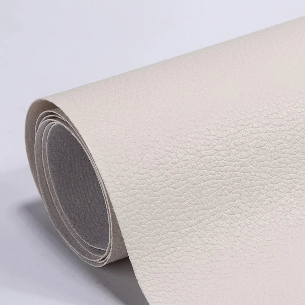 A roll of cream-coloured, textured self-adhesive leather repair patch material on a plain white background.