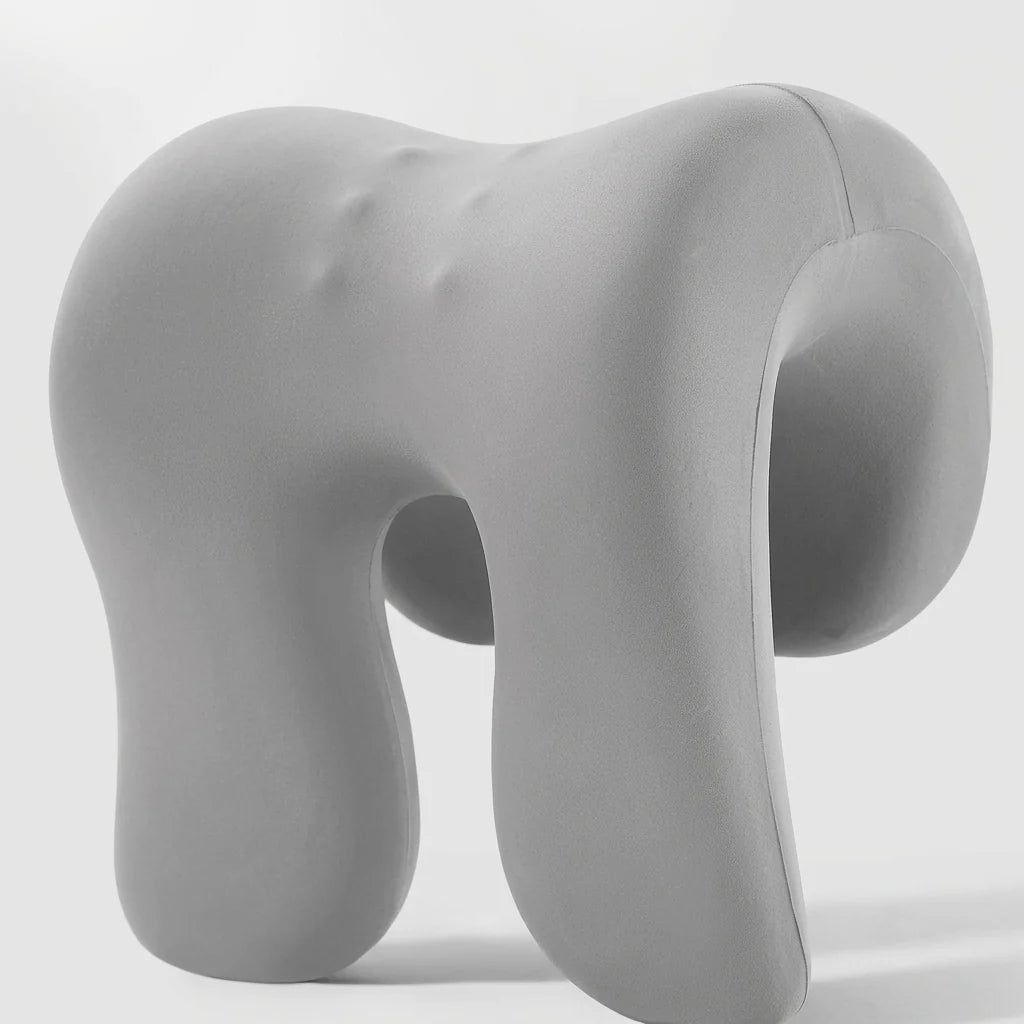 A grey, ergonomic memory foam neck support pillow with small massage points on its surface, set against a plain background.
