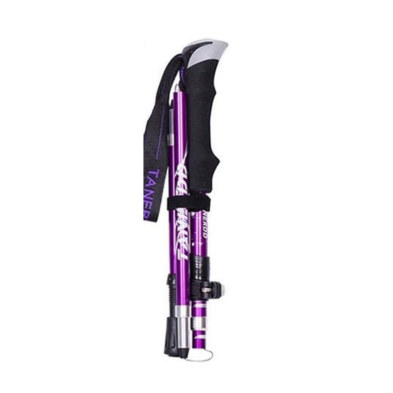 A foldable purple trekking pole with a black handle and wrist strap, shown in its collapsed state.