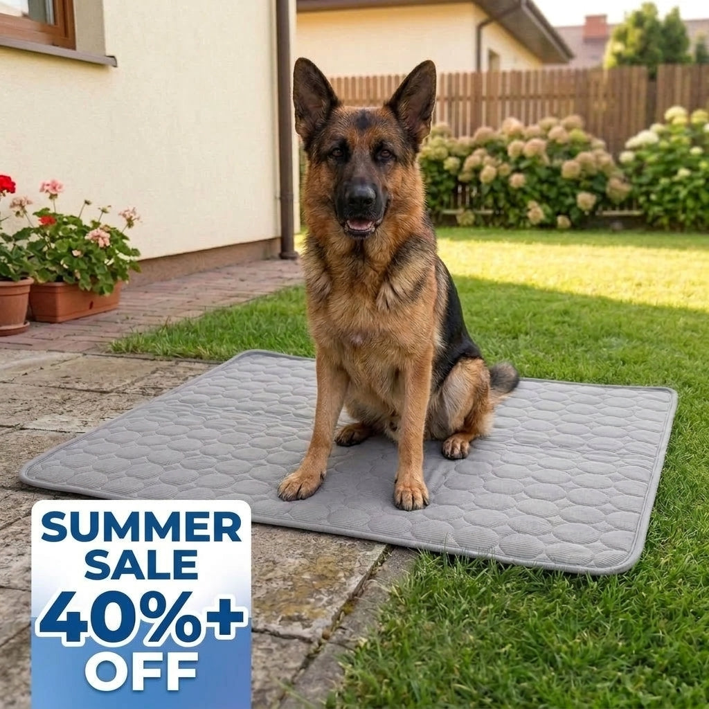 A German Shepherd sitting on a grey, quilted cooling mat placed on a paved patio in a garden, with a summer sale graphic.