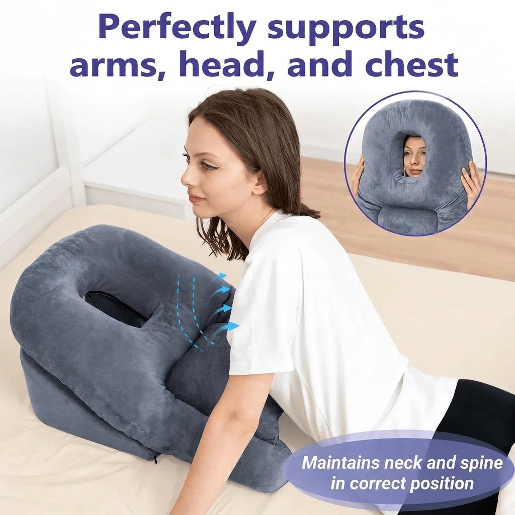 A woman lying face-down on a bed using a grey memory foam stomach pillow designed for post-surgery recovery.